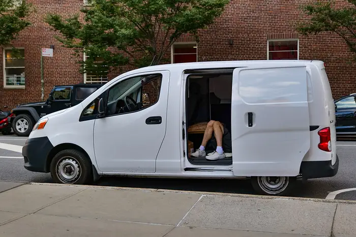 A photo of a person's legs in the back of a van